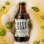 A creative and quirky image of a bottle of beer transformed into a luxurious soap. The soap has a frothy, bubbly texture and is adorned with hops and barley, retaining the essence of the original beer. The label on the soap reads 'Beer Soap: A Hoppy Shower Experience!', adding a playful and humorous touch to the design. The overall ambiance is inviting and refreshing, with a touch of craft beer culture.