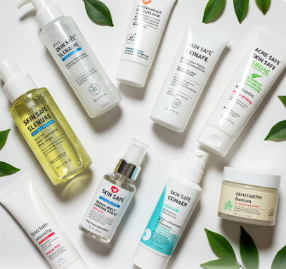 A flat lay of various skincare products on a white background with green leaves